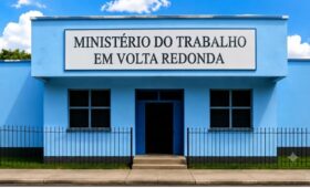 Fotografia da fachada do prédio do Ministério do Trabalho em Volta Redonda com pintura azul e placa oficial de identificação.