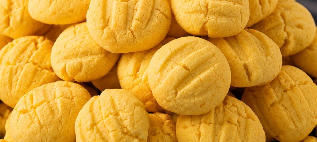 Close em uma pilha de biscoitos de maracujá caseiros amarelos redondos com marcas de garfo na parte superior.