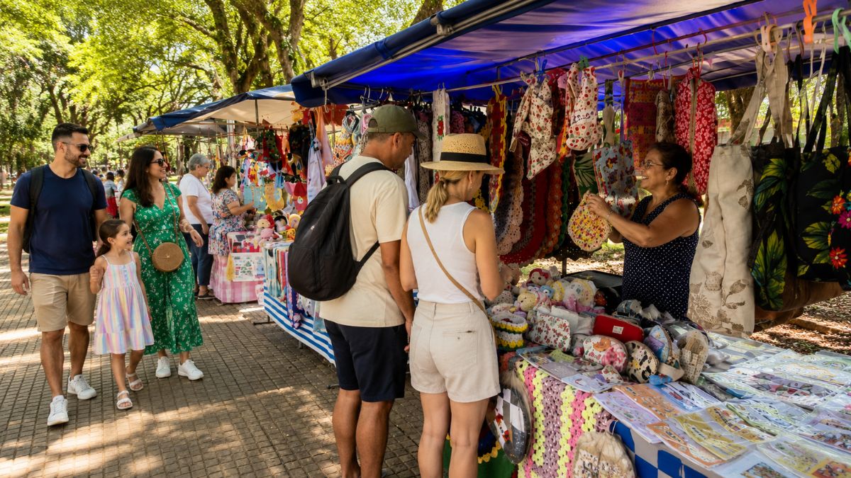 Turistas e moradores compram artesanato local em barracas ao ar livre na praça de Mendes.
