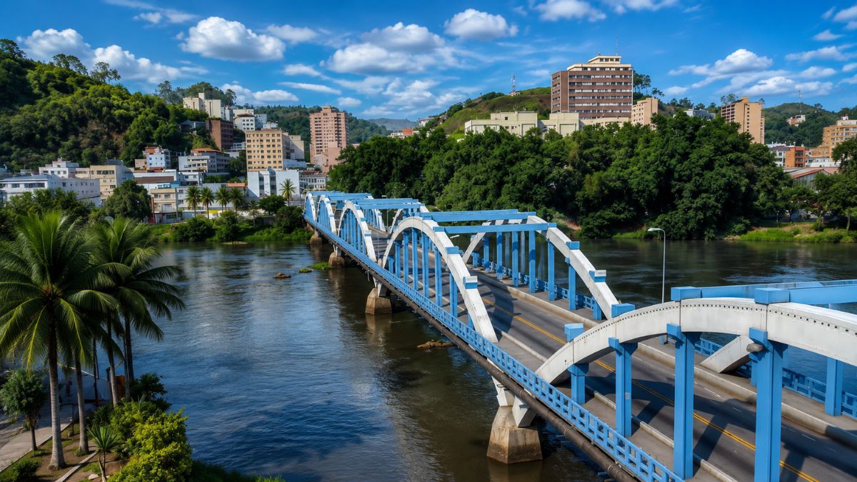 Fotografia da Ponte Ataulfo de Paiva em Barra Mansa no Vale do Café, destacando a estrutura em arcos brancos e azuis sobre o Rio Paraíba do Sul com edifícios urbanos ao fundo.