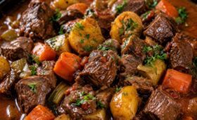 Fotografia em close de um ensopado suculento de carne de panela com cubos de acém cozidos batatas cenouras pimentões e aipo envoltos em um molho marrom rico e salpicados com salsa fresca